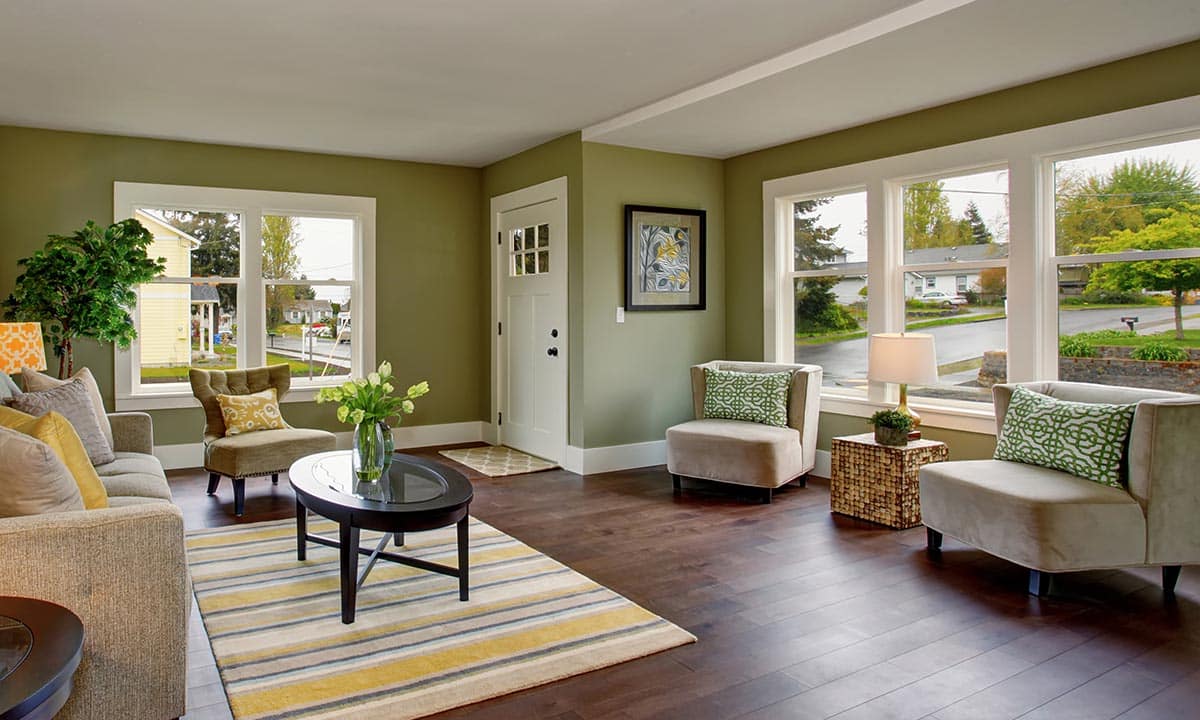 Well decorated living room with hardwood floor, and green yellow theme.