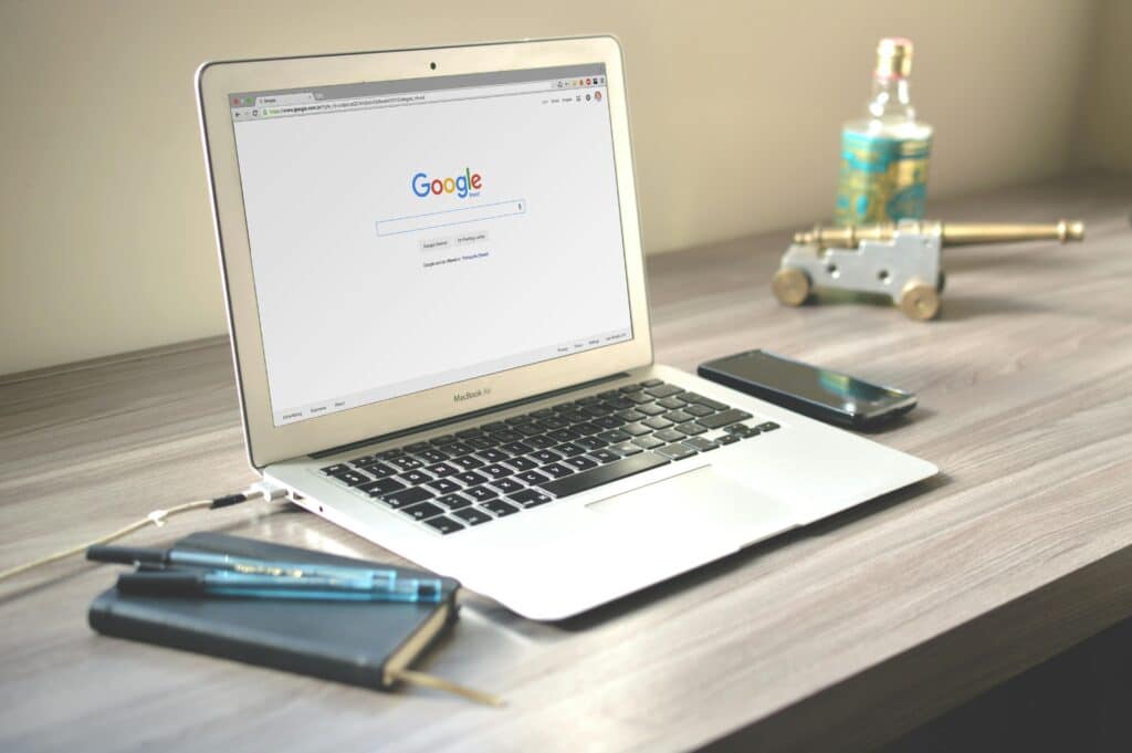 Laptop searching on Google for enhancing your online presence on top of desk 