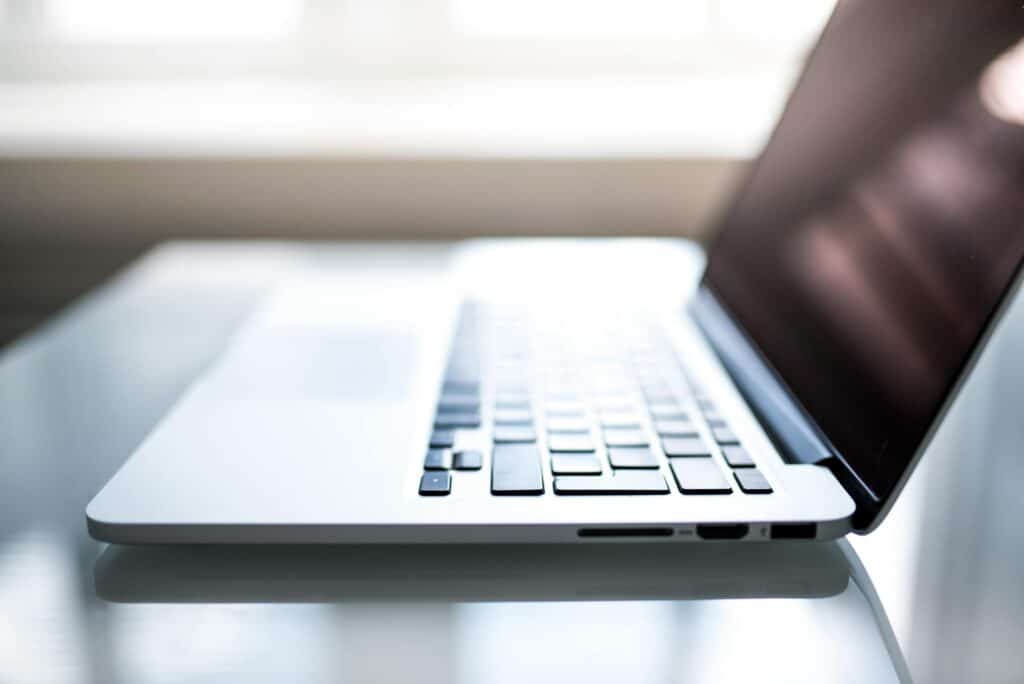 Laptop on table from side view teaching how to attract customers online